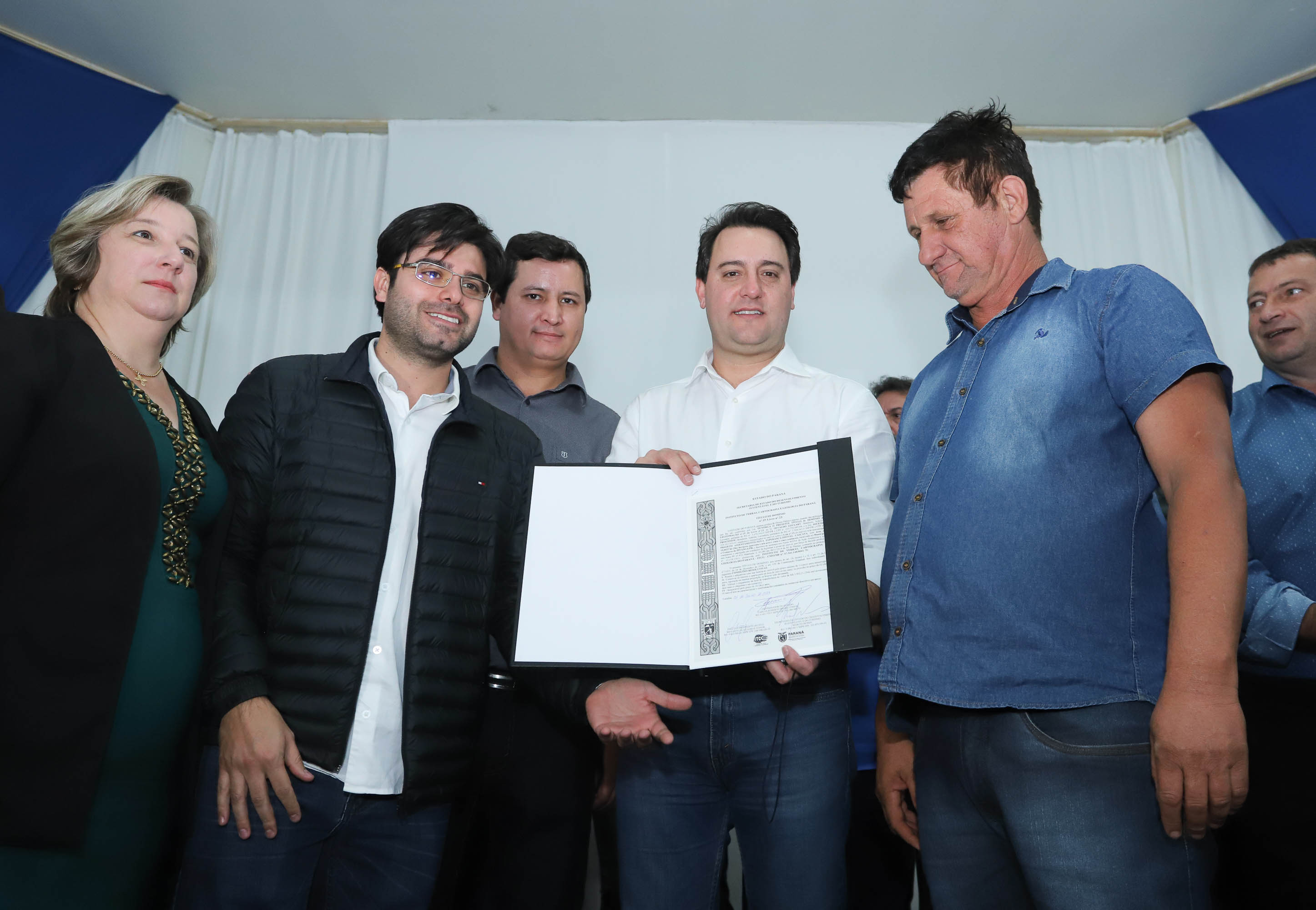 Cinquenta e seis famílias de produtores rurais ocupantes de terras pertencentes ao Estado (devolutas) em Pitanga e Boa Ventura do São Roque, no Centro do Paraná, receberam nesta sexta-feira (7) os títulos de propriedade de seus imóveis. Aguardado há anos pelas famílias, o documento de regularização das terras foi entregue em encontro com o governador Carlos Massa Ratinho Junior, realizado em Pitanga. Foto: Rodrigo Felix Leal/ANPr
