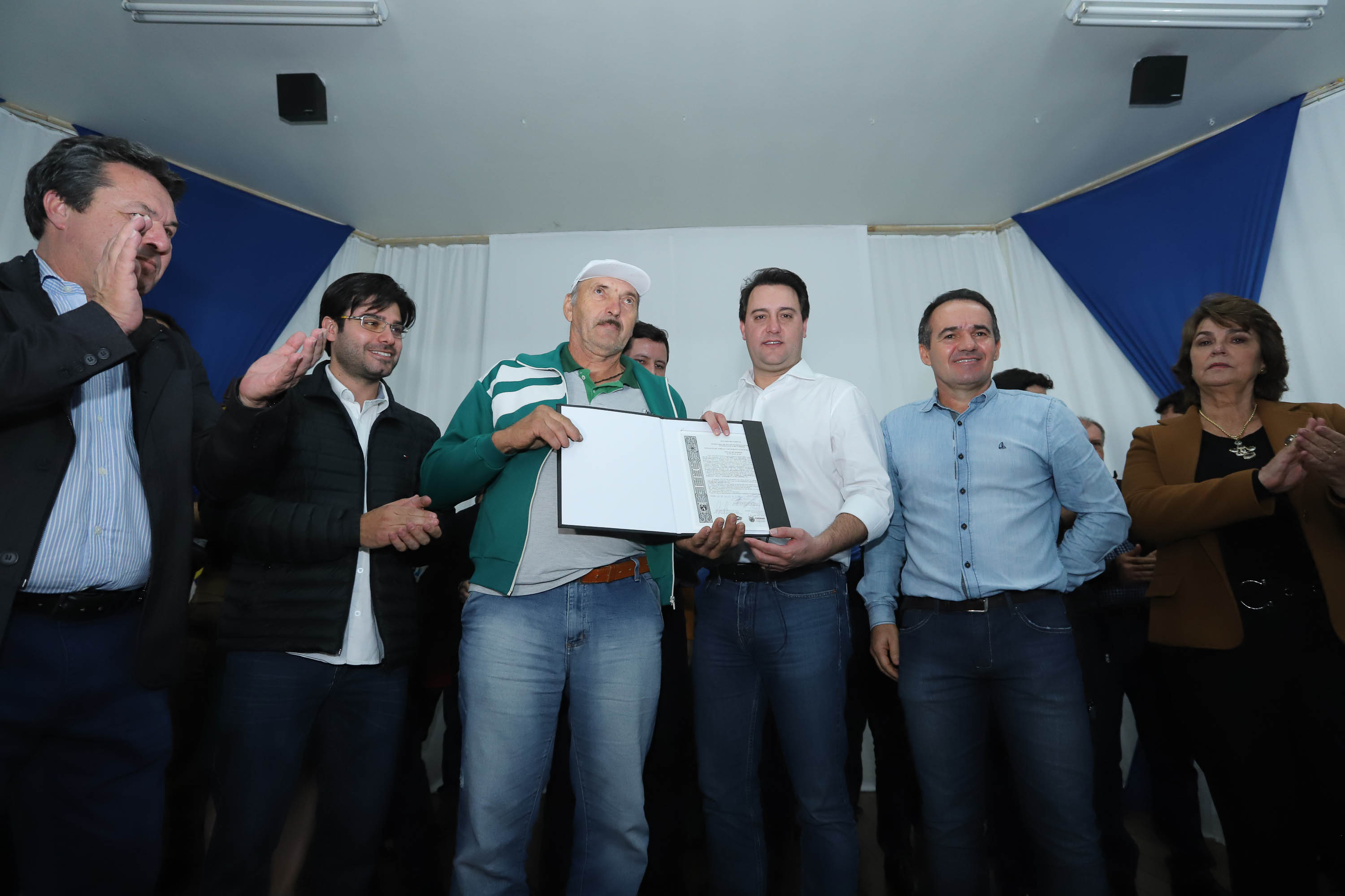 Cinquenta e seis famílias de produtores rurais ocupantes de terras pertencentes ao Estado (devolutas) em Pitanga e Boa Ventura do São Roque, no Centro do Paraná, receberam nesta sexta-feira (7) os títulos de propriedade de seus imóveis. Aguardado há anos pelas famílias, o documento de regularização das terras foi entregue em encontro com o governador Carlos Massa Ratinho Junior, realizado em Pitanga. Foto: Rodrigo Felix Leal/ANPr