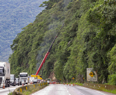 Morretes, 10 de fevereiro de 2023 - Guindastes realizam a recuperação do morro na BR 277, sentindo litoral paranaense, nas proximidades do viaduto do padre.