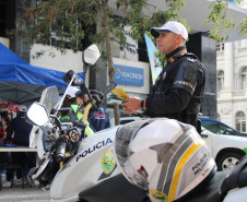 Ciclistas e pedestres da XV de Novembro, em Curitiba, recebem materiais educativos do trânsito