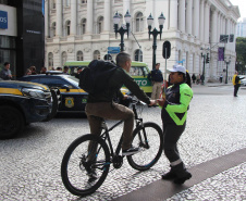 Ciclistas e pedestres da XV de Novembro, em Curitiba, recebem materiais educativos do trânsito