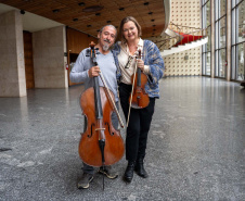 Entre tantos personagens e histórias, também nasceu uma história de amor. Foi tocando quase de frente um para o outro - ele no violoncelo, ela no violino - que Romildo Weingartner, músico desde a fundação da Orquestra em 1985, conheceu Juliane Martens.