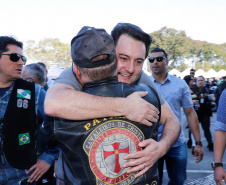 O governador Carlos Massa Ratinho Junior disse neste sábado (27) que o Governo do Paraná prepara, em parceria com motociclistas, uma agenda turística robusta para integrar ainda mais os clubes e potencializar as viagens ao encontro das belezas naturais do Estado. Ele participou das comemorações da 1ª Moto União, no Palácio Iguaçu, evento idealizado pelo Departamento de Trânsito do Paraná (Detran-PR) que passa a fazer parte do calendário estadual em razão do Dia do Motociclista. 