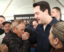 O governador Carlos Massa Ratinho Junior entregou nesta quinta-feira (15) os títulos de propriedades de imóveis para 367 famílias de Paranaguá, no Litoral. Elas ocupam terras devolutas, pertencentes ao Estado. A titulação corresponde a uma área de aproximadamente 112 hectares, abrangendo as localidades de Jardim Jacarandá e Ouro Fino, no perímetro urbano de Paranaguá. Foto: Gilson Abreu/AEN
