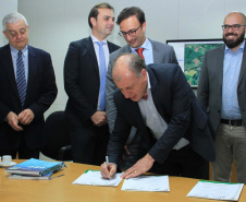 O Governo do Estado deu início nesta terça-feira (03) a mais um projeto inovador. O secretário do Desenvolvimento Urbano e de Obras Pública, João Carlos Ortega, assinou Memorando de Entendimento entre o Paranacidade, o Green Building Council Brasil (GBC BR) e a Fomento Paraná  para transformar as escolas municipais de todo o Estado em geradoras de energia elétrica fotovoltaica e qualificá-las para alcançar a condição de consumo zero de energia de origem externa. Foto: Divulgação/SEDU