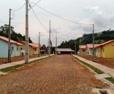  Nesta quinta-feira (26), dezessete famílias de Salgado Filho que viviam em condições precárias ou que pagavam aluguel conquistaram uma casa própria sem precisar pagar nada por isso. A construção do residencial na cidade, na região Sudoeste, recebeu R$ 1,1 milhão de investimento do Governo do Estado, por meio de um financiamento internacional obtido junto ao BID, em um trabalho integrado da Cohapar, Secretaria da Justiça, Família e Trabalho e prefeitura. (Foto: Eduardo Cioatto / Cohapar)