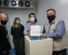 O  Secretário de Estado da Saúde, Beto Preto e o vice-prefeito Eduardo Pimentel recebem o primeiro lote de  32.760 doses de vacinas contra a Covid-19 da  Pfizer   no Centro de Medicamentos do Paraná (Cemepar), em Curitiba, na noite desta segunda-feira (3).  Foto: Geraldo Bubniak/AEN
