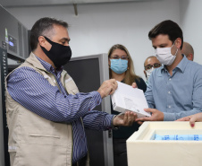 O  Secretário de Estado da Saúde, Beto Preto e o vice-prefeito Eduardo Pimentel recebem o primeiro lote de  32.760 doses de vacinas contra a Covid-19 da  Pfizer   no Centro de Medicamentos do Paraná (Cemepar), em Curitiba, na noite desta segunda-feira (3).  Foto: Geraldo Bubniak/AEN