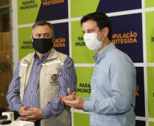 O  Secretário de Estado da Saúde, Beto Preto e o vice-prefeito Eduardo Pimentel recebem o primeiro lote de  32.760 doses de vacinas contra a Covid-19 da  Pfizer   no Centro de Medicamentos do Paraná (Cemepar), em Curitiba, na noite desta segunda-feira (3).  Foto: Geraldo Bubniak/AEN