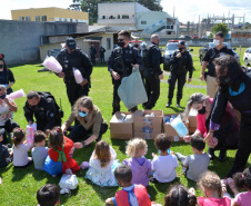 Servidores do Departamento Penitenciário do Paraná organizaram uma campanha para arrecadação de doces e brinquedos que foram entregues nesta quarta-feira (13), a crianças do Centro Municipal de Educação Infantil Ana Maria, em Piraquara, na Região Metropolitana de Curitiba. Além dos presentes, uma apresentação com cães que atuam no sistema prisional alegrou a tarde da criançada.  -  Curitiba, 14/10/2021 - Foto: DEPEN/PR